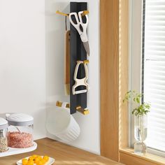 a kitchen counter with utensils hanging on the wall next to bowls and spoons