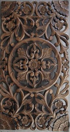 an intricate carved wood panel with flowers and leaves