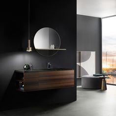 a modern bathroom with black walls and white flooring, round mirror on the wall