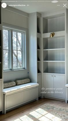 an empty room with built - in bookshelves and window seat on the far wall