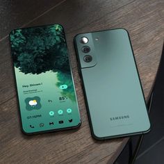 two smartphones sitting on top of a wooden table next to each other, one green and the other blue