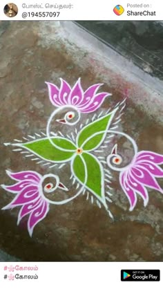 a flower design painted on the ground with white and pink flowers in front of it