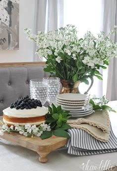 a table topped with a cake covered in white flowers