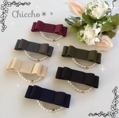 four different colors of hair clips with pearls on the side and flowers in the background