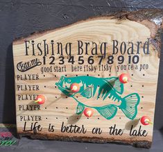 a wooden sign with fish on the lake written in black and green lettering, along with other words