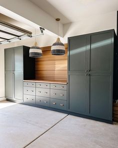 an empty room with cabinets and lights hanging from the ceiling