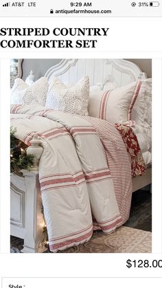 a white bed with red and white striped comforter set