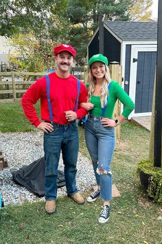 a man and woman standing next to each other in front of a small shed,