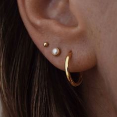 a woman's ear with two small pearls on it