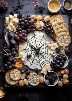 a table topped with crackers, grapes and cheese