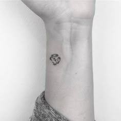 a black and white photo of a woman's wrist with a small tattoo on it