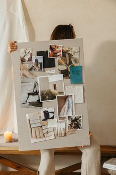 a woman holding up a white board with pictures on it