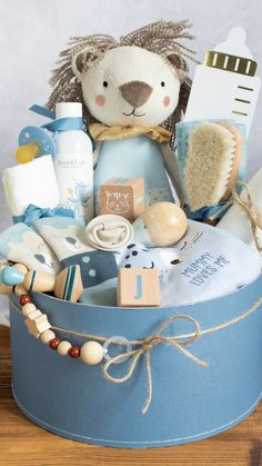 a blue basket filled with baby items on top of a wooden table