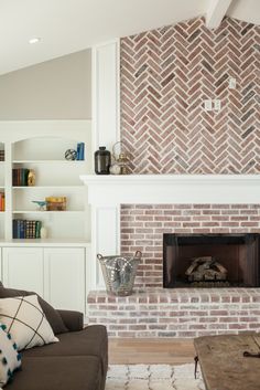 a living room with a fire place and bookshelves on the wall above it