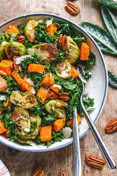 a bowl filled with brussel sprouts, carrots and pecans