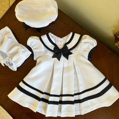 Nwot Rare Editions Dress Is A White And Navy Blue Color, With Matching Hat And Panties. Classic Cuteness In New Condition! See Close Up Picture For Colors And Details Navy Fitted Cute Dress, Cute Fitted Navy Dress, Fitted Lined Dresses For Playtime, White Sailor Dresses For Spring, White Sailor Style Dress For Spring, White Sailor Style Spring Dress, Sailor Style White Cotton Dress, White Cotton Sailor Dress, White Sailor Cotton Dress