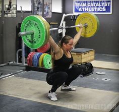 a woman doing squats with a barbell