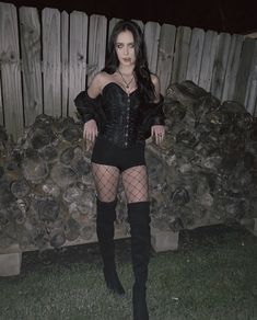 a woman in fishnet stockings and thigh high boots posing for the camera with her hands on her hips