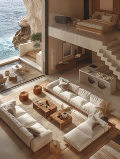 a living room filled with lots of furniture next to a large glass window overlooking the ocean