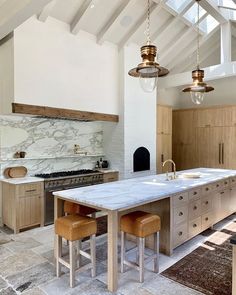 a kitchen with marble counter tops and an island in the middle, surrounded by wooden cabinets