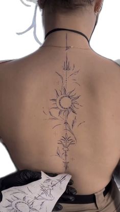 the back of a woman's neck with tattoos on her upper and lower back