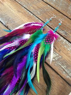 colorful feathers are hanging on the side of a wooden table