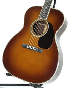 an acoustic guitar sitting on top of a stand