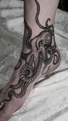 an octopus tattoo is on the foot of a woman's leg and it looks like she has been tattooed