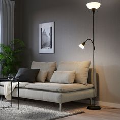 a living room scene with focus on the couch and floor lamp in the foreground