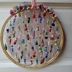 a colorful beaded wall hanging on the side of a white door with flowers and beads