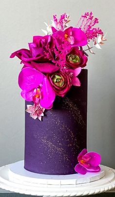 a purple cake with pink flowers on top