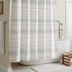 a bathroom with a white shower curtain next to a bath tub