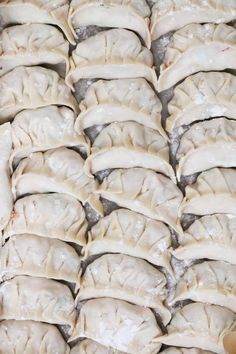 many dumplings are stacked on top of each other and ready to be cooked in the oven