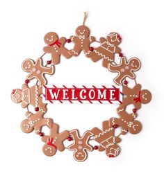 a christmas ornament that says welcome with gingerbreads and candy canes