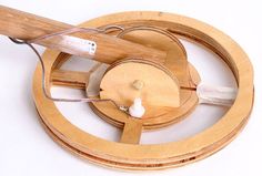 a wooden spinning wheel with an electric wire connected to it and two wires running through the center