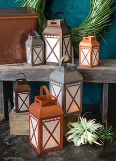 three small lanterns are sitting on a bench