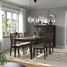 a dining room table and chairs in front of a window