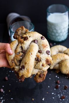 a person holding up a chocolate chip cookie