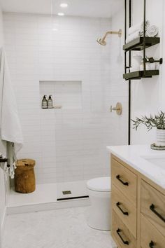 a bathroom with white tile and wooden cabinetry is shown in this image, the shower door is open