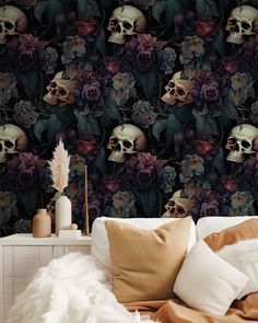 there is a bed with pillows and a skull wallpaper on the wall next to it