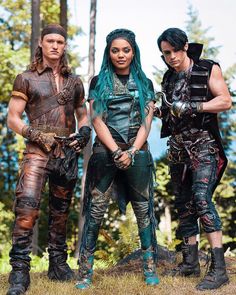 two men and a woman dressed up in leathers standing next to each other with their arms around one another