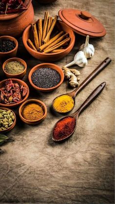 spices and herbs are arranged in bowls on a table