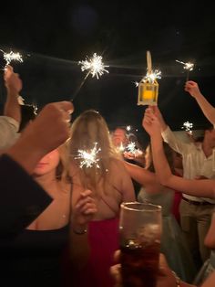 people holding sparklers in their hands at a party