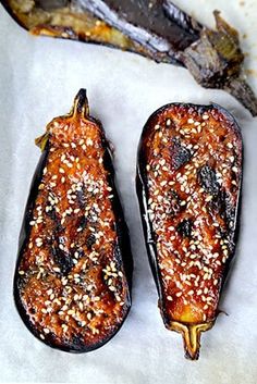 two stuffed eggplant halves with sesame seeds on them and the words nasu dengaku above it