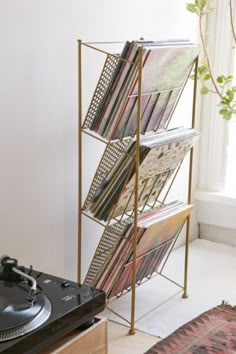 a record player sitting next to a rack with records on it