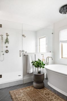 a bathroom with a tub, shower and rug