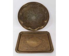 two brass trays, one in the shape of a bowl and one with an intricate design