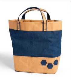 a blue and tan tote bag sitting on top of a white table