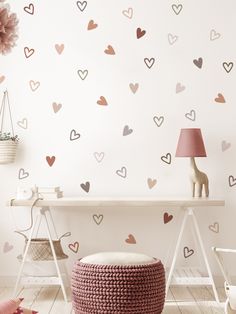 a room with hearts painted on the wall and a pink chair in front of it