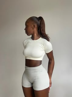 a woman in white shorts and a crop top